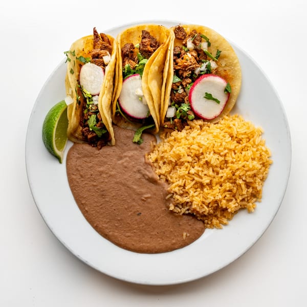 Three Casa De Avila Tacos with meat, cilantro, onions, and radishes, served with rice and refried beans.